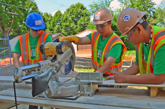 UnderConstruction interns (L to R) Andy Johnson, Ger Yang and Marcus Byington saw materials for a new garage in Frogtown.