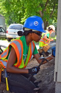 Sapphire Thompson (near) and Pheng Lee nail siding to the garage.
