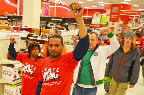 Retail cleaning workers and other supporters of raising the state's minimum wage march in silence through the Target downtown Minneapolis.