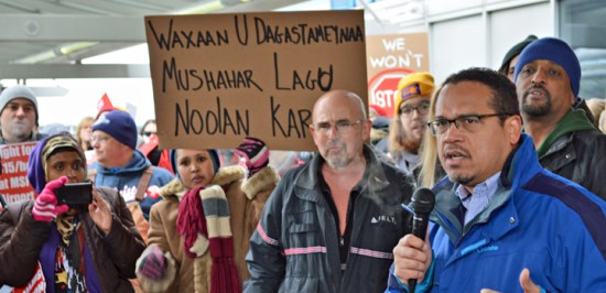 U.S. Rep. Keith Ellison speaks in support of fired Delta baggage handler Kip Hedges (blue coat) at a rally at MSP Airport.