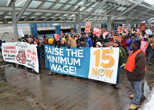 About 200 people joined the march along outside the upper level of Terminal 1, calling for $15 wages and union rights.