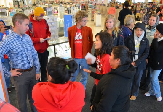 Rosalia Morales, wearing a black sweatshirt, confronts a manager in Kohl's Roseville store about working conditions at the company's cleaning subcontractor Kimco.