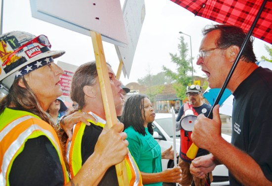 Operating Engineers Local 49 member Vahne Angelino (L) and her wife Melissa confront one of Scott Walker's supporters outside a campaign stop in St. Paul.