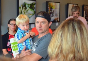 Lake Monster Brewing co-owner Matt Zanetti explains his support of a citywide sick-time ordinance while holding his son, Leo.
