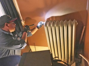Local 455 volunteer Luis Parad, a service professional from NAC, checked for leaks in the radiator of a house on Carroll Avenue in St. Paul. 