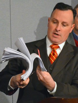 Rep. John Lesch flips through a stack of incident reports he obtained from the City of St. Paul, stemming from calls for police service made by the Midway Walmart over a the course of one year.