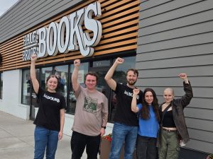 Workers with fists raised outside a Half Price Books store